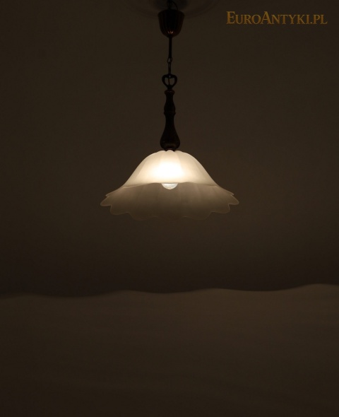 widok całej zapalonej lampy na tle ściany