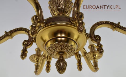 Stary eklektyczny żyrandol mosiężny w kolorze złotym.