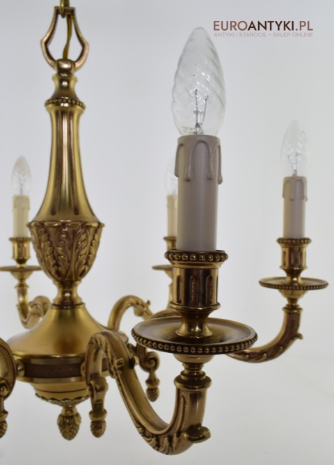 Stary eklektyczny żyrandol mosiężny w kolorze złotym.