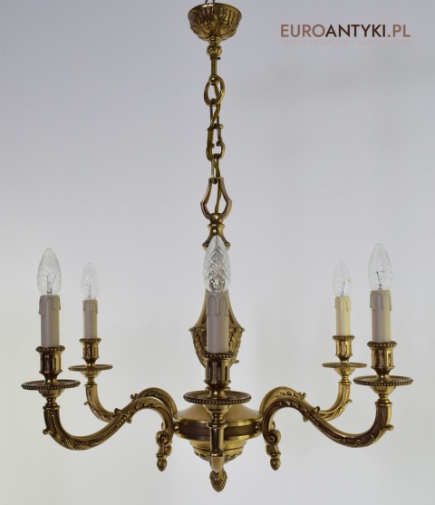 Stary eklektyczny żyrandol mosiężny w kolorze złotym.