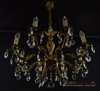 Zabytkowy żyrandol mosieżny z kryształami do barokowego pałacu.